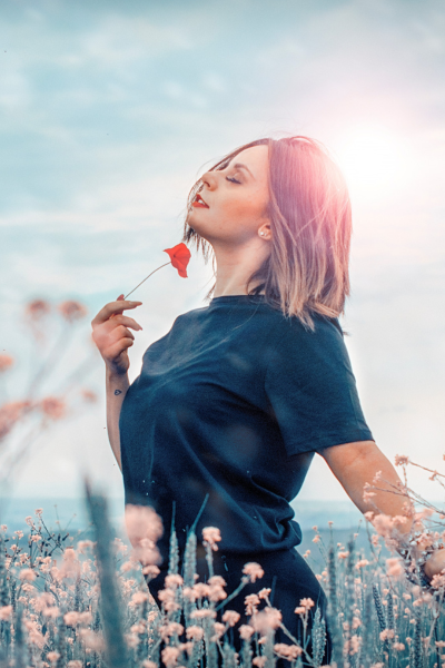 Imagem de mulher feliz e plena a segurar uma papoila. Imagem retirada de freepik